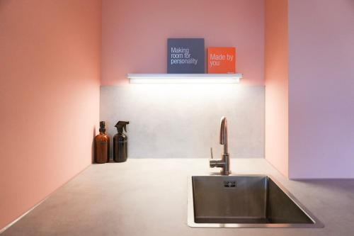 a kitchen with a sink and two bottles on the wall at Design Apartment Plön in Plön