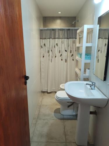 a bathroom with a white toilet and a sink at Las Toribias II in El Rincón