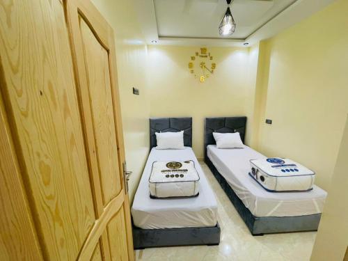 two beds in a small room with a door at Waves Surf House in Taghazout