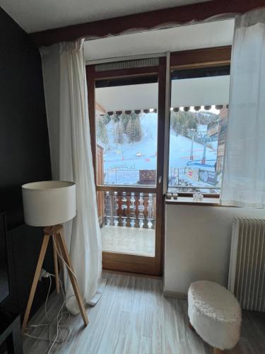 a room with a large window with a view of a ski slope at Praloup 1600 t3 sur piste 4p in Uvernet