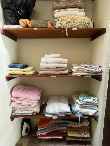 a closet filled with lots of shirts and towels at Canto do Cururuá - IlhaBela in Ilhabela