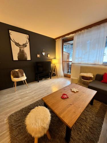 a living room with a coffee table and a deer on the wall at Praloup 1600 t3 sur piste 4p in Uvernet