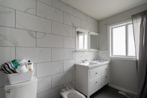 a white bathroom with a toilet and a sink at Spacious Bright Home In Woodbridge in Vaughan