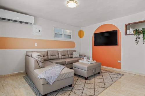 a living room with a couch and a flat screen tv at Comfortable Home for 6 Near Airport & Beaches in Carolina