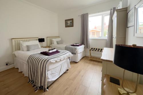a bedroom with two beds and a tv and a window at Tawaw Bungalow South Shields in South Shields