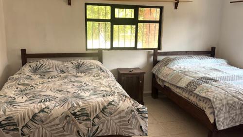 a bedroom with two beds and a window at La isla encantada in Aculco de Espinoza