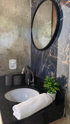 a bathroom with a sink and a mirror at Bangalô em uma área próxima a praia e centro in Porto Seguro