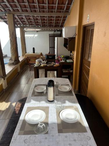 a kitchen with a table with plates and glasses on it at Pousada Maracajaú in Maracajaú