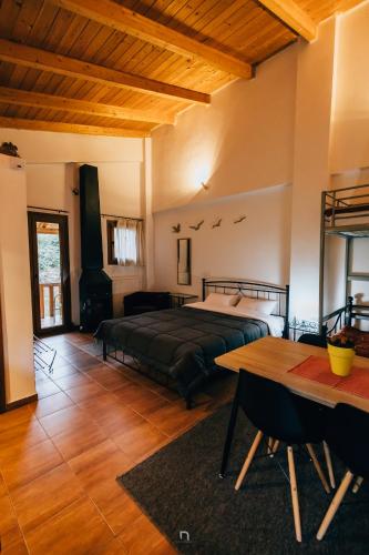 ein großes Schlafzimmer mit einem Bett und einem Tisch in der Unterkunft Michel Studios in Kalavryta