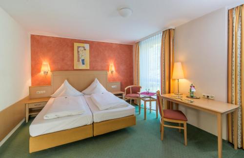 una camera d'albergo con un letto e una scrivania di Hotel Waldmühle a Zella-Mehlis