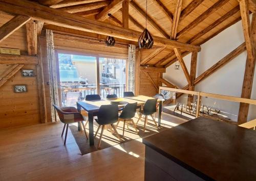 a dining room with a table and chairs at Chalet Lucien, Jacuzzi, Les 3 Vallées in Villarly