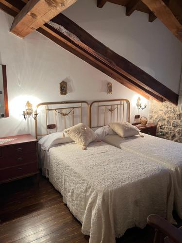a bedroom with a large bed with white sheets at Casa del Herrador II in Carrascal del Río