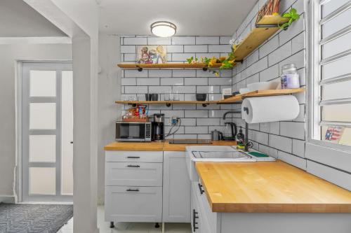 a kitchen with white cabinets and a sink at Perfect Group Retreat for 10 Near Beach & Airport in Carolina