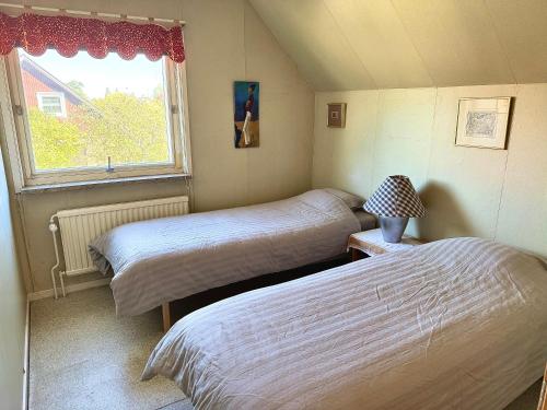 two beds in a small room with a window at Villa in central Visby in Visby
