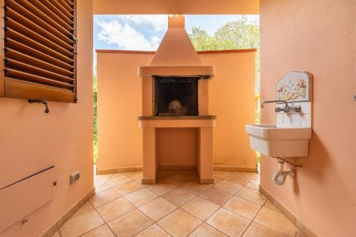 a bathroom with a fireplace in the middle of a room at Villa Del Sole- in Costa Rei