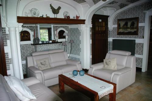 a living room with two chairs and a coffee table at B&B Le Maquis in De Haan