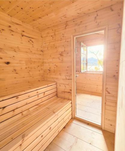 an empty wooden sauna with an open window at Villa Tegernsee - Exclusive Lakefront Villa with private Zirben Sauna, 4 Rooms for Family & Friends in Tegernsee