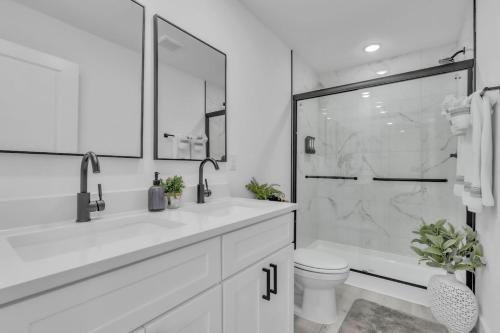 a white bathroom with a shower and a toilet at 3 BR Downtown Spartanburg- Upscale& Work Ready "Sweet Carolina Cottage" in Spartanburg