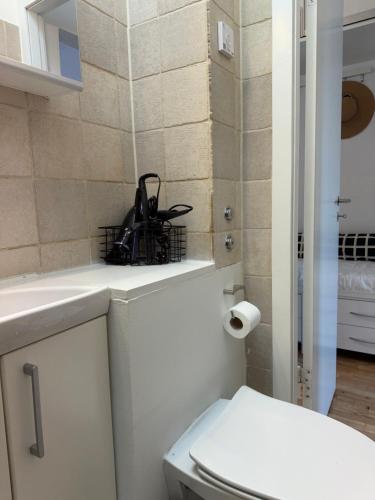 a bathroom with a toilet with a black purse on the counter at Balcony Apartment - Lyngby Great Copenhagen in Kongens Lyngby