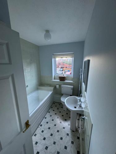 a white bathroom with a tub and a sink at Poole Harbour View in Poole