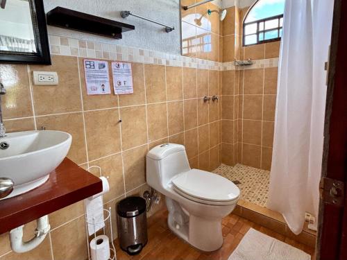 a bathroom with a toilet and a sink at Hotel & Restaurant Fleur de Lis in Concepción de Ataco