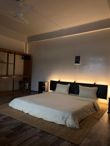 a bedroom with a large bed with white sheets and pillows at The Southside Den in Āīzawl