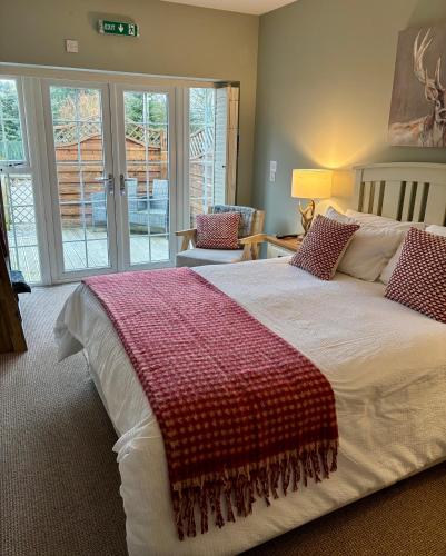 a bedroom with a large bed with a red blanket on it at Blenkinsopp Castle Inn in Greenhead