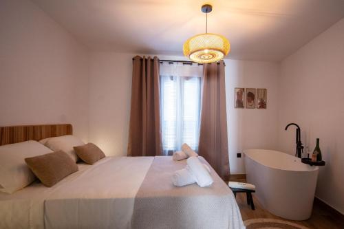 a bedroom with a bed and a tub and a window at Casa Los Yayos in Segorbe
