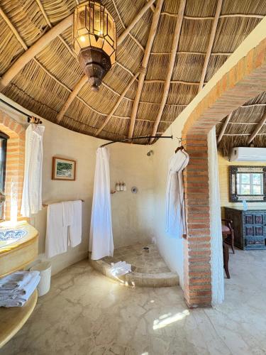 a room with a bathroom with a bed and a ceiling at Tia Adriana in Sayulita
