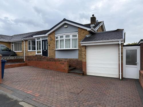 a brick house with a white garage at Stunning 2 Bedroom Bungalow - Free Parking - Convenient Location in Cox Green