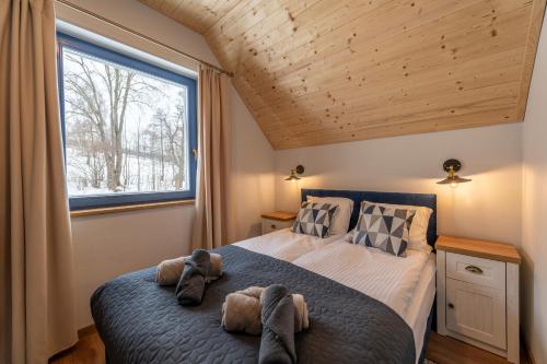 a bedroom with a bed with two stuffed animals on it at Osada Niebieskich Drzwi 39 B in Stronie Śląskie