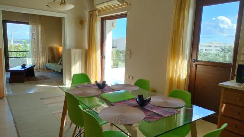 a dining room with a table and green chairs at Spata sunrise house in Spata