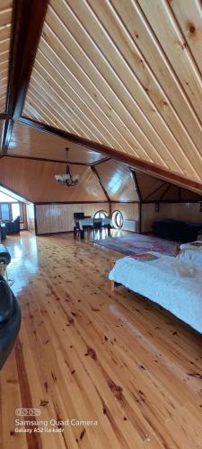 una grande stanza con un letto e un pavimento in legno di Villa Qeçreş a Quba