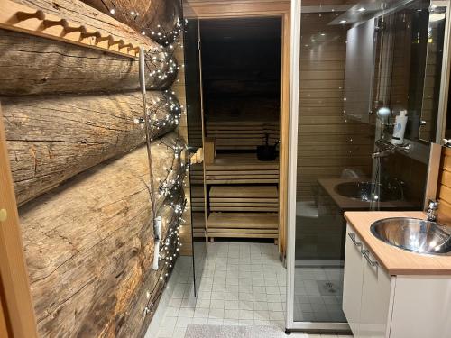 a bathroom with a sink and a wooden wall at Ruka Chalet Roma in Ruka