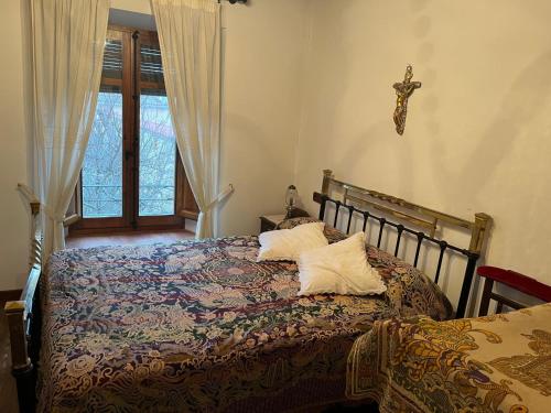 a bedroom with a bed with a cross on the wall at Casa del Herrador I in Carrascal del Río
