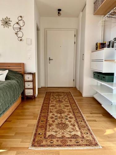 a bedroom with a bed and a door with a rug at Studio Horizon Dorigny in Lausanne