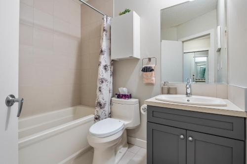 a bathroom with a toilet and a sink and a tub at Entire Home - 2 Separate Units in Calgary