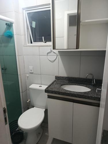 a bathroom with a toilet and a sink and a mirror at Rogerio AP Compartilhado in Caucaia