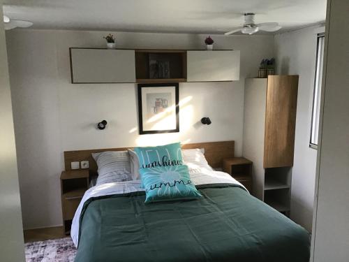 a bedroom with a bed with a green comforter at Bien dans le sud in Fréjus