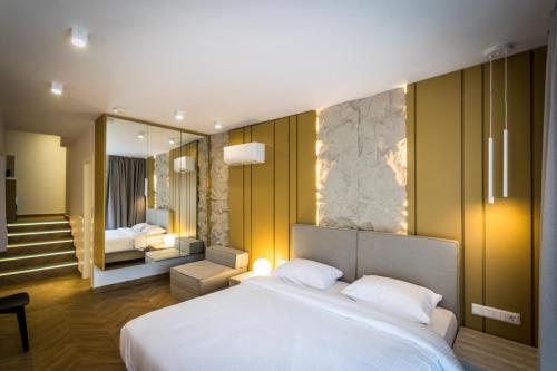 a bedroom with a large white bed and a mirror at City Breeze Suites in Heraklio