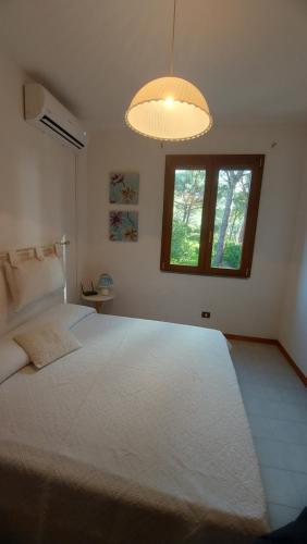 a bedroom with a large white bed with a window at Casa Licia Sorso in Marina di Sorso
