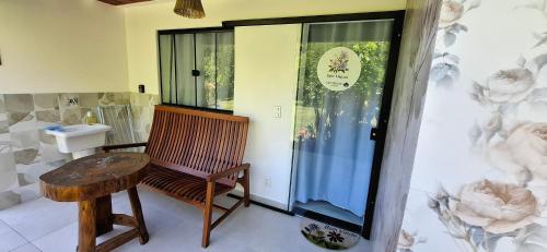a bathroom with a wooden bench and a sink at Rio Sereno Suítes Comfort - Lumiar in Lumiar