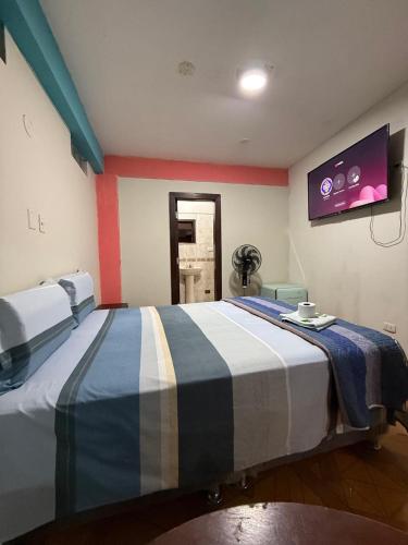una camera da letto con un letto grande con una TV a parete di Hostal Muchik a Chiclayo