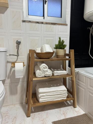 a bathroom with a wooden shelf with towels at Adoria GuestHouse in Adoria