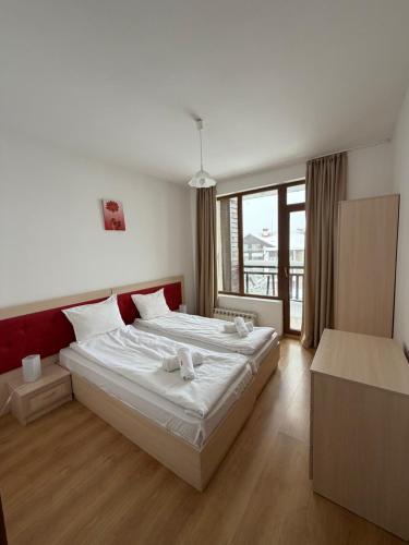 a bedroom with a bed with two stuffed animals on it at PM Services Semiramida Apartments in Borovets