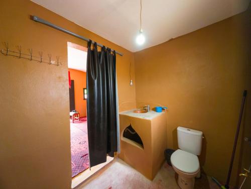 ein Badezimmer mit weißer Toilette und Waschbecken in der Unterkunft Sahara Peace camp in Zagora