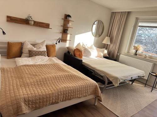 a bedroom with two beds and a mirror at LakeCity Apartment in Klagenfurt