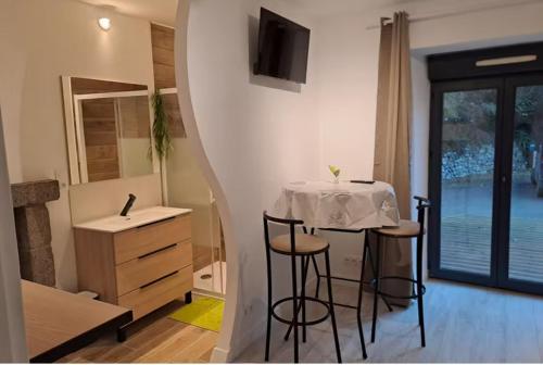 Cosy d'Yffiniac في Yffiniac: مطبخ به طاولة وكراسي في غرفة