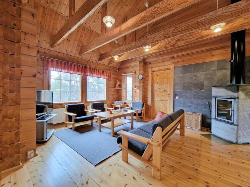 a living room with wooden walls and a fireplace at Paratiisikuru 2 in Kakslauttanen