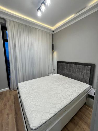 a bedroom with a large white bed in a room at Qarb Apartment Dernegul metro in Baku